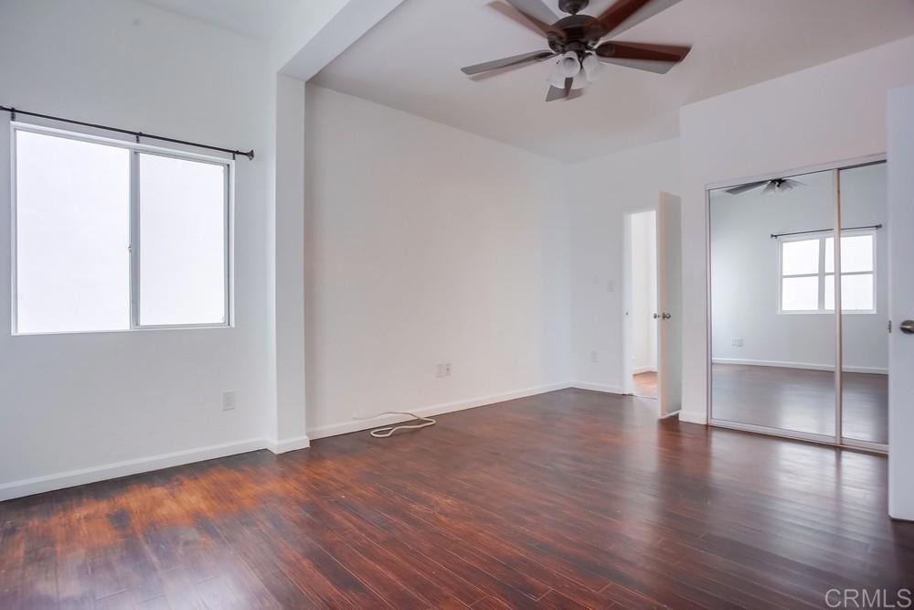 1295 Prospect Street, Unit D La Jolla, CA 92037 - Photo 19 of 24 an empty room with wooden floor fan and windows