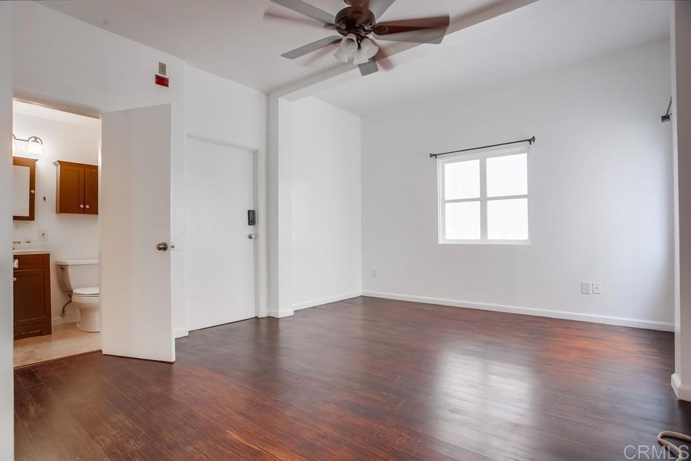 1295 Prospect Street, Unit D La Jolla, CA 92037 - Photo 20 of 24 an empty room with wooden floor and windows