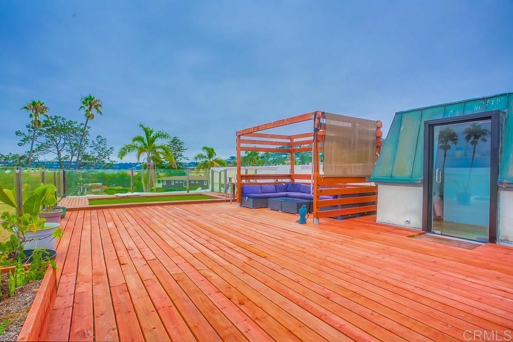 1295 Prospect Street, Unit D La Jolla, CA 92037 - Photo 23 of 24 a backyard of a house with wooden floor and outdoor seating