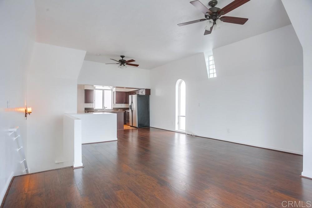 1295 Prospect Street, Unit D La Jolla, CA 92037 - Photo 6 of 24 an empty room with wooden floor fan and windows
