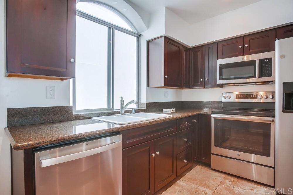 1295 Prospect Street, Unit D La Jolla, CA 92037 - Photo 7 of 24 a kitchen with stainless steel appliances granite countertop a sink and a microwave
