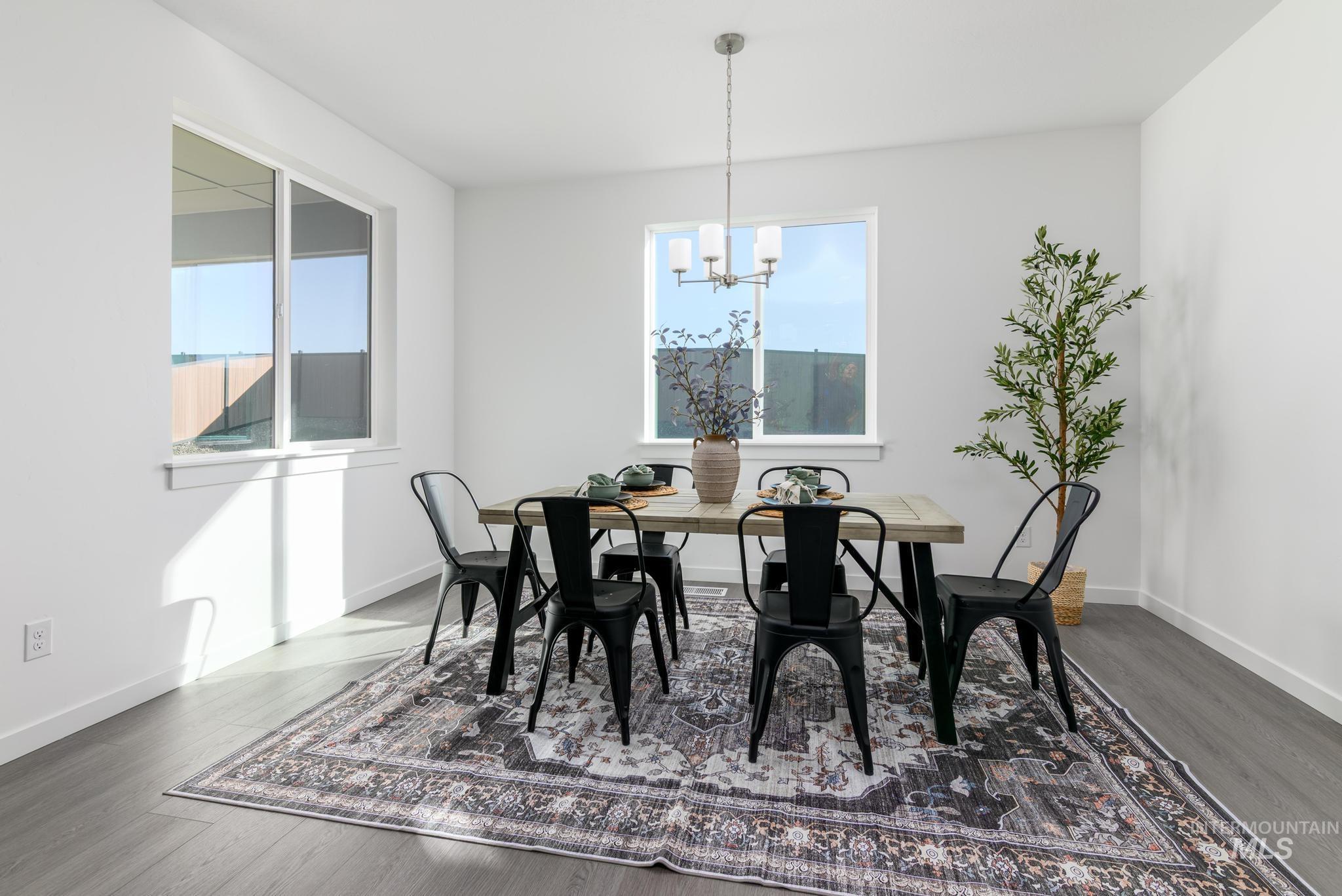 1932 Chokecherry Avenue Middleton, ID 83644 - Photo 6 of 11 Dining space with healthy amount of natural light, dark wood-type flooring, and a chandelier