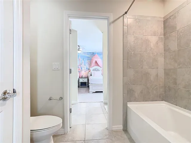 a bedroom with a bed and a mirror on the dresser