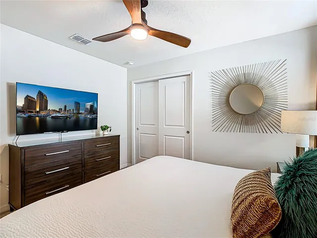 a bedroom with a bed and painting on the wall