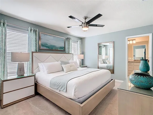a bedroom with a bed window and mirror on the dresser