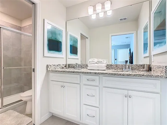 a bedroom with a large bed and a chandelier fan