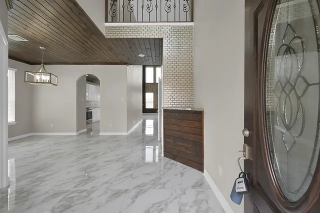 a view of a hallway with wooden floor and a glass door