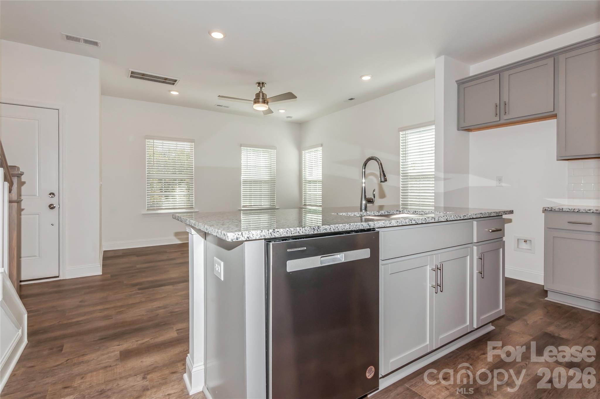 6002 Cedar Chip Way Matthews, NC 28105 - Photo 11 of 35 a kitchen with kitchen island granite countertop a sink cabinets and wooden floor