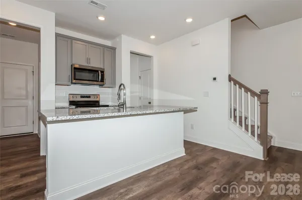 a kitchen with stainless steel appliances granite countertop a stove a sink and a refrigerator