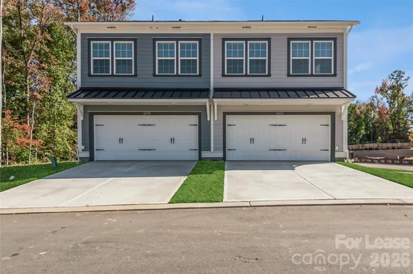 front view of a house with a bench and a garage