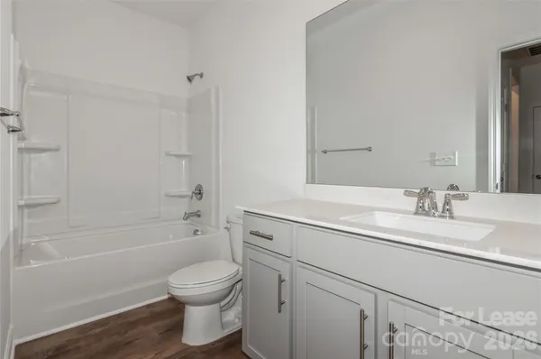 a bathroom with a granite countertop sink a toilet and shower