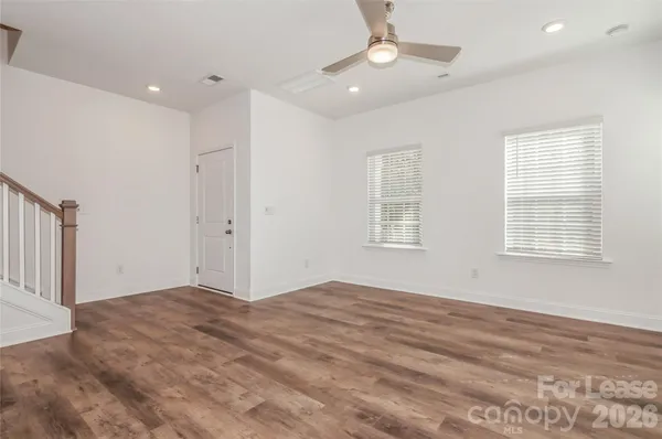 an empty room with windows and ceiling fan