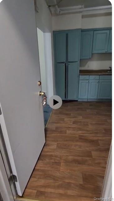 488 Nassau Road, Unit 2 Roosevelt, NY 11575 - Photo 1 of 2 Kitchen with dark wood-style floors and blue cabinetry