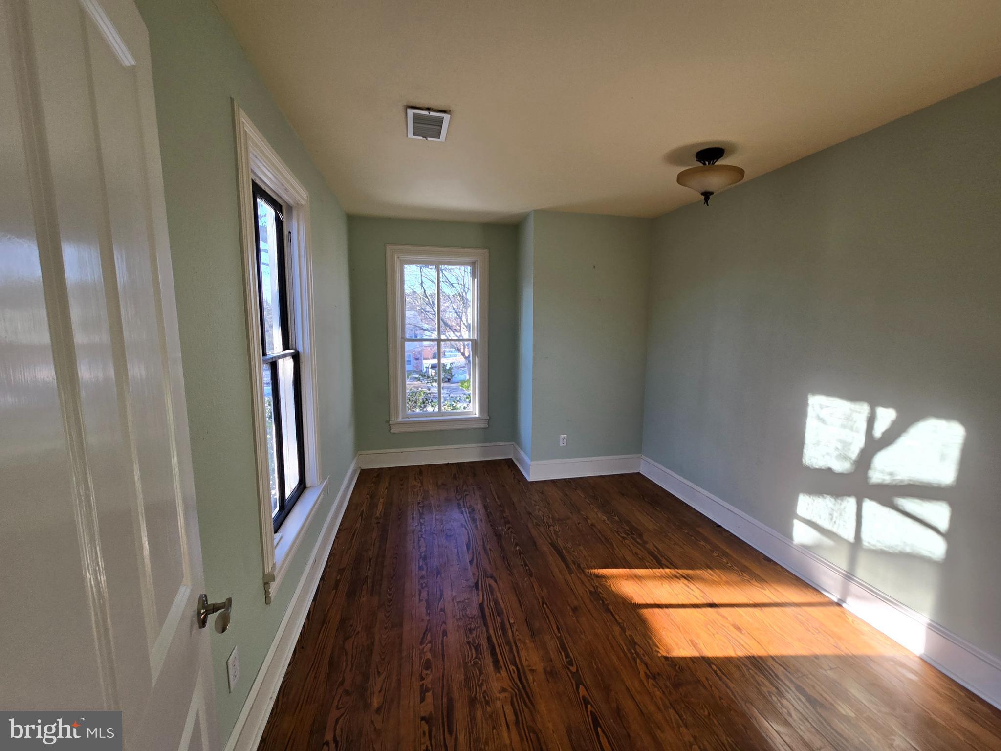 101 Chapel Road Easton, MD 21601 - Photo 13 of 35 an empty room with wooden floor and windows