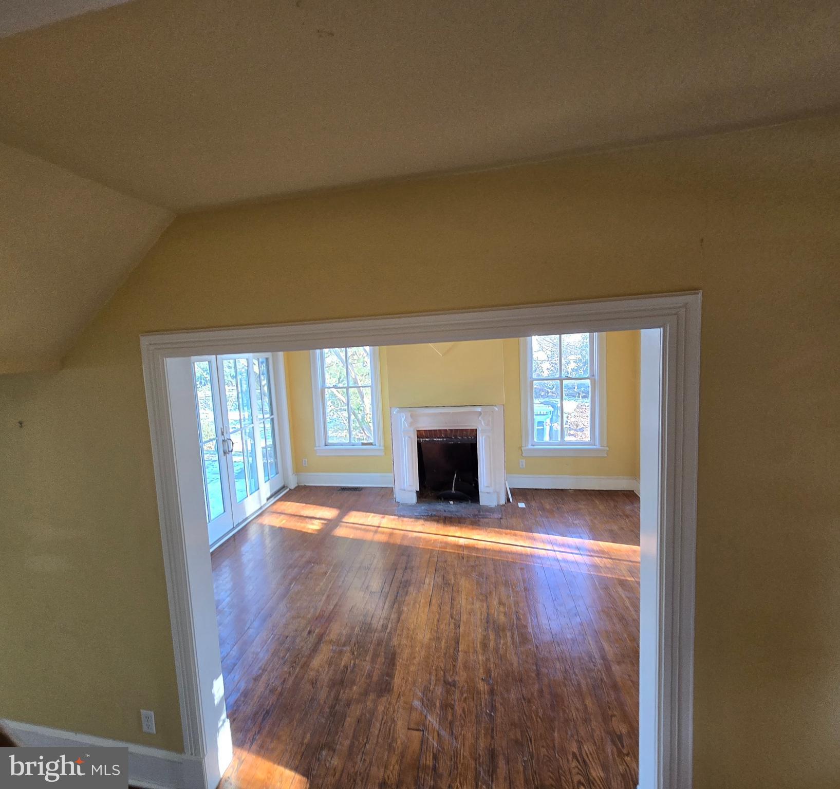 101 Chapel Road Easton, MD 21601 - Photo 18 of 35 an empty room with wooden floor fireplace and windows