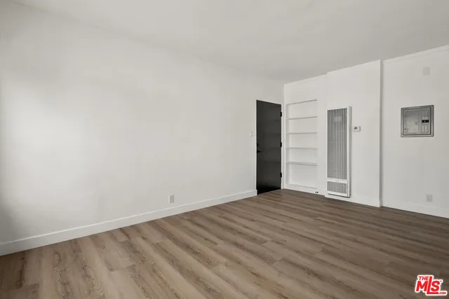 a view of an empty room with wooden floor
