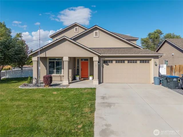 a front view of a house with a yard and garage