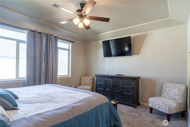 a bedroom with a bed a couch and a flat screen tv