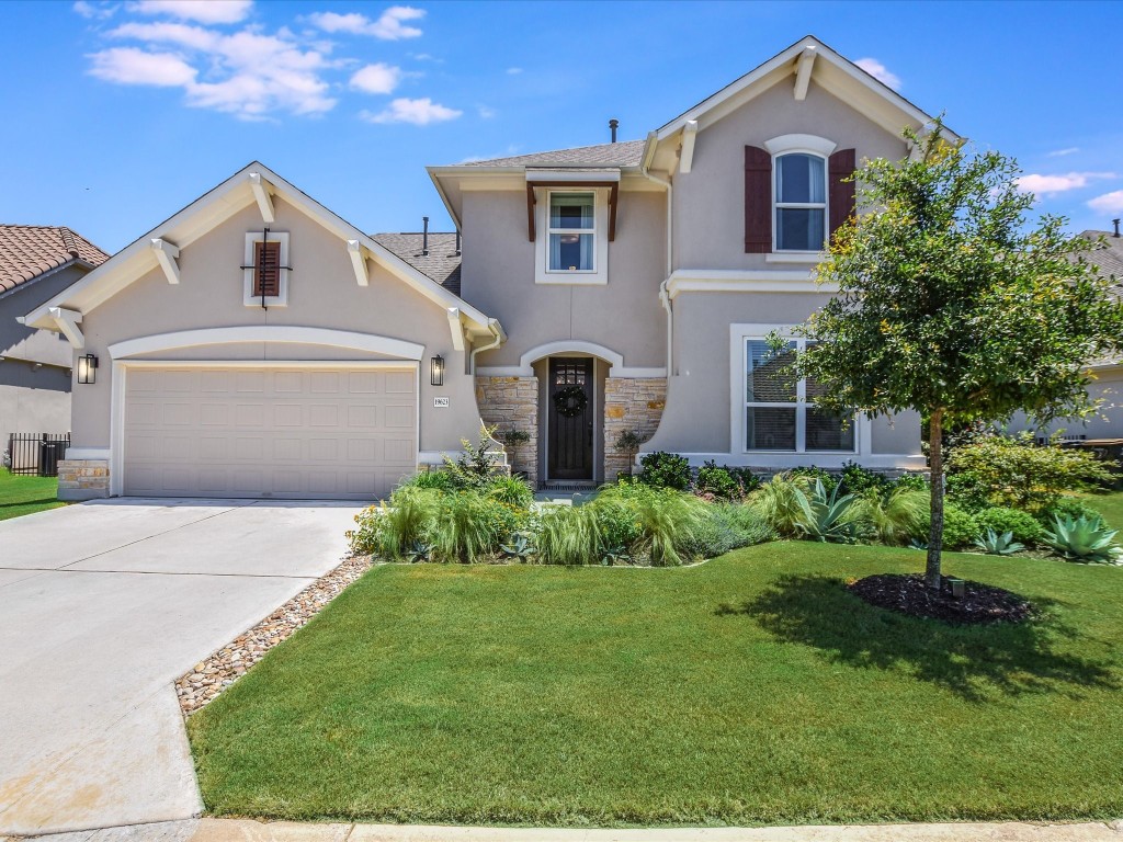This home offers spectacular curb appeal with lush landscaping, a stucco exterior, elegant stone accents, and a welcoming, arched front entry.