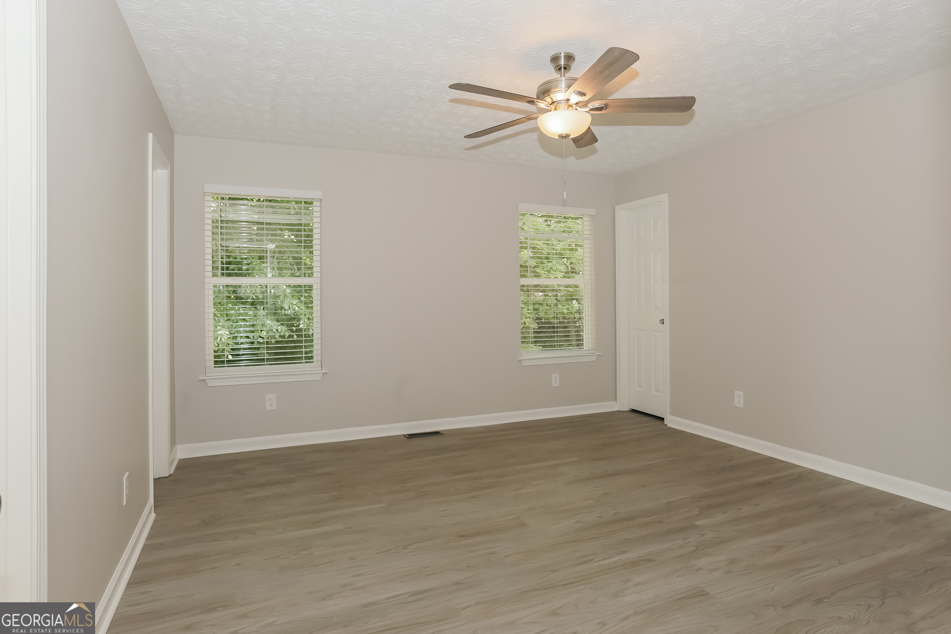2983 Rapids Drive Decatur, GA 30034 - Photo 7 of 17 an empty room with wooden floor fan and windows