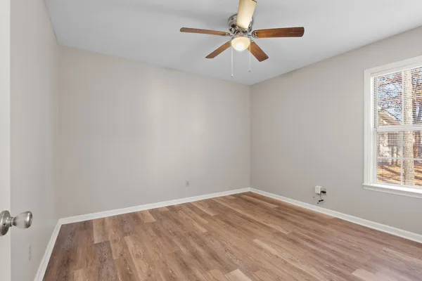 an empty room with a window and a fan