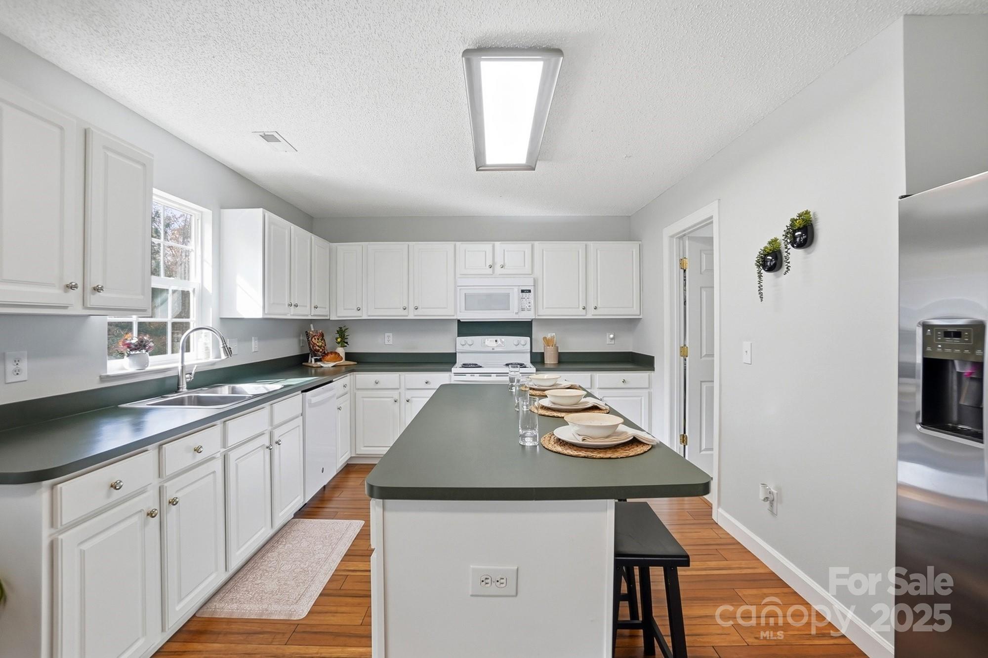 143 Amber Woods Drive Tega Cay, SC 29708 - Photo 12 of 46 a kitchen with a sink a stove cabinets and a refrigerator