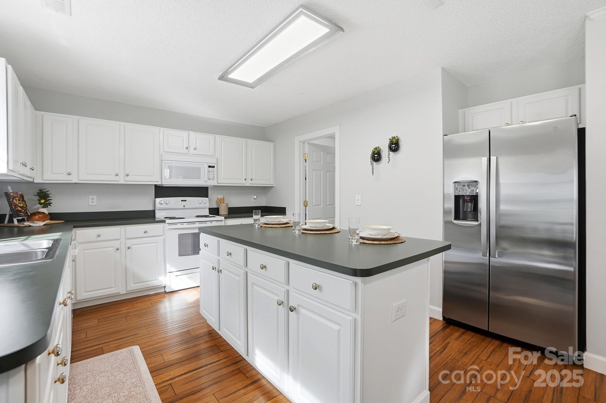 143 Amber Woods Drive Tega Cay, SC 29708 - Photo 13 of 46 a kitchen with stainless steel appliances granite countertop a refrigerator a sink and white cabinets