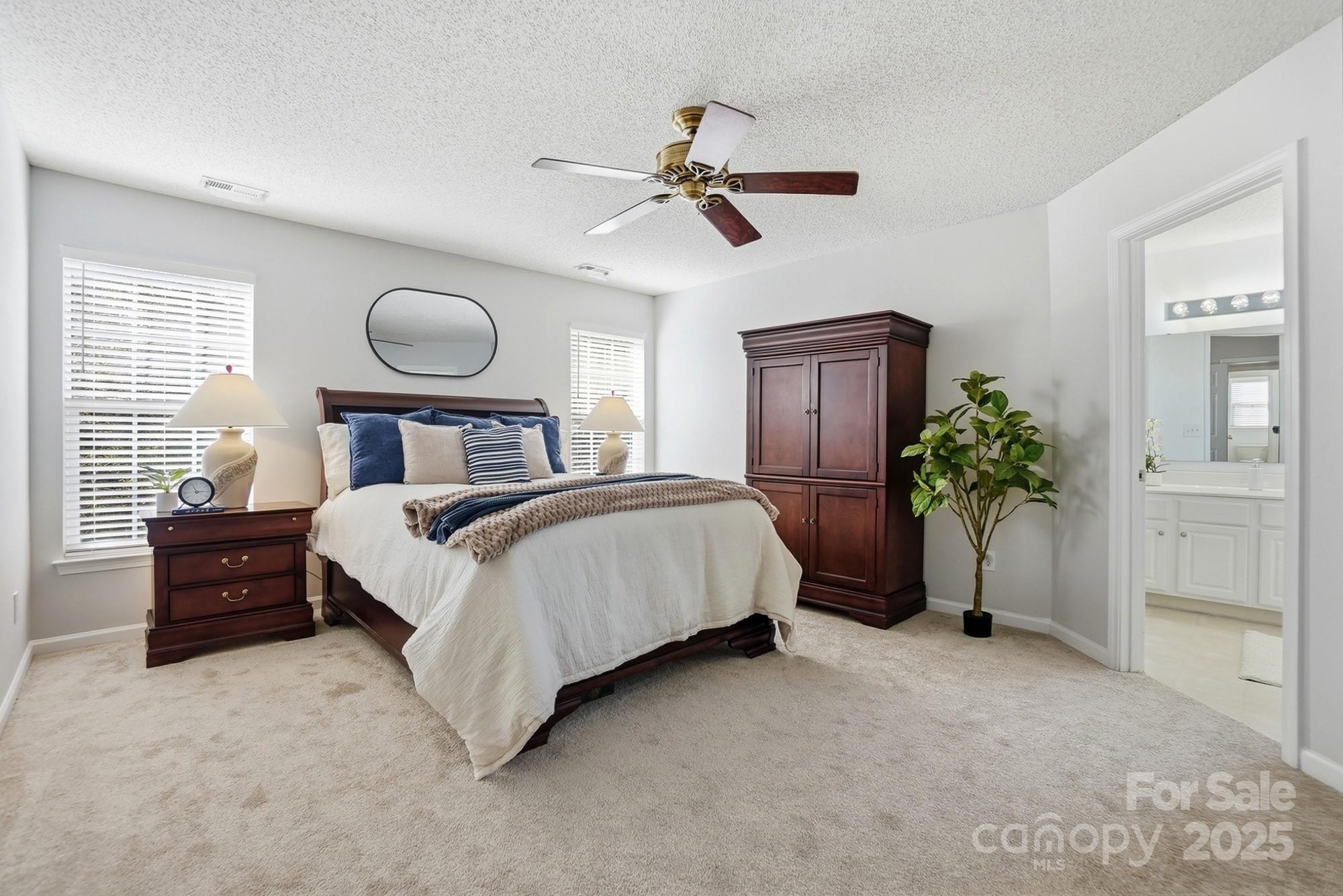 143 Amber Woods Drive Tega Cay, SC 29708 - Photo 25 of 46 a bedroom with a bed and a chandelier