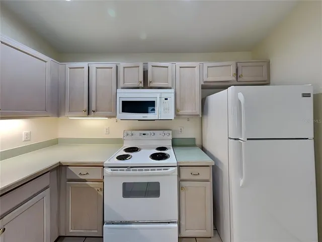a kitchen with refrigerator a stove a microwave and cabinets