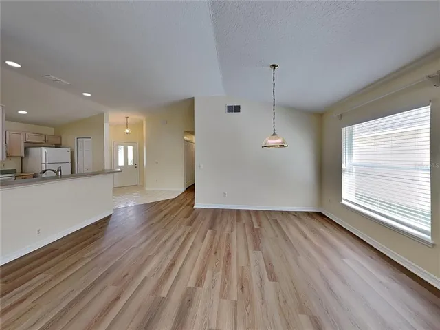 a view of a kitchen with wooden floor and a window
