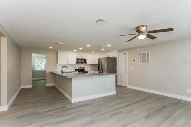 a view of kitchen with sink microwave and refrigerator