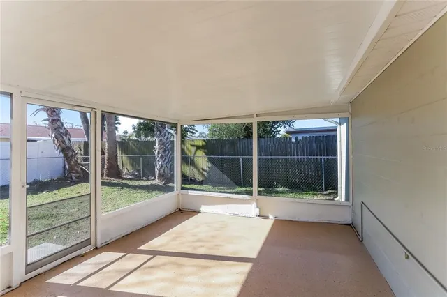 an empty room with wooden floor and ceiling fan