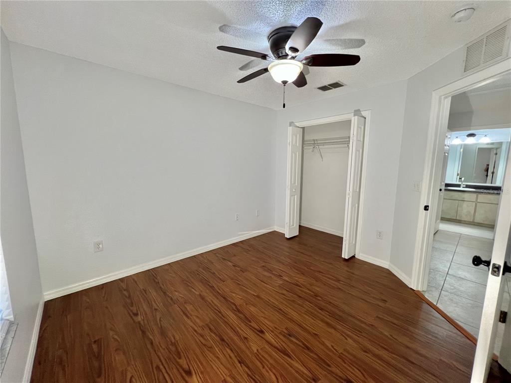 7469 Pond Circle Spring Hill, FL 34606 - Photo 15 of 22 a view of empty room with wooden floor and ceiling fan