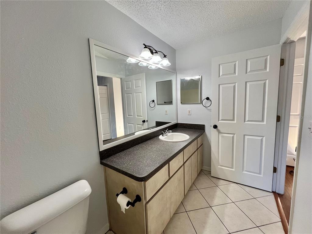 7469 Pond Circle Spring Hill, FL 34606 - Photo 20 of 22 a bathroom with a sink a mirror and a toilet
