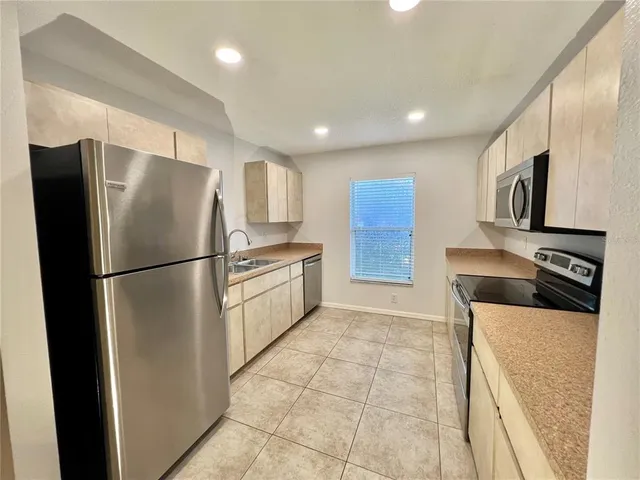 a kitchen with a sink a refrigerator and a mirror