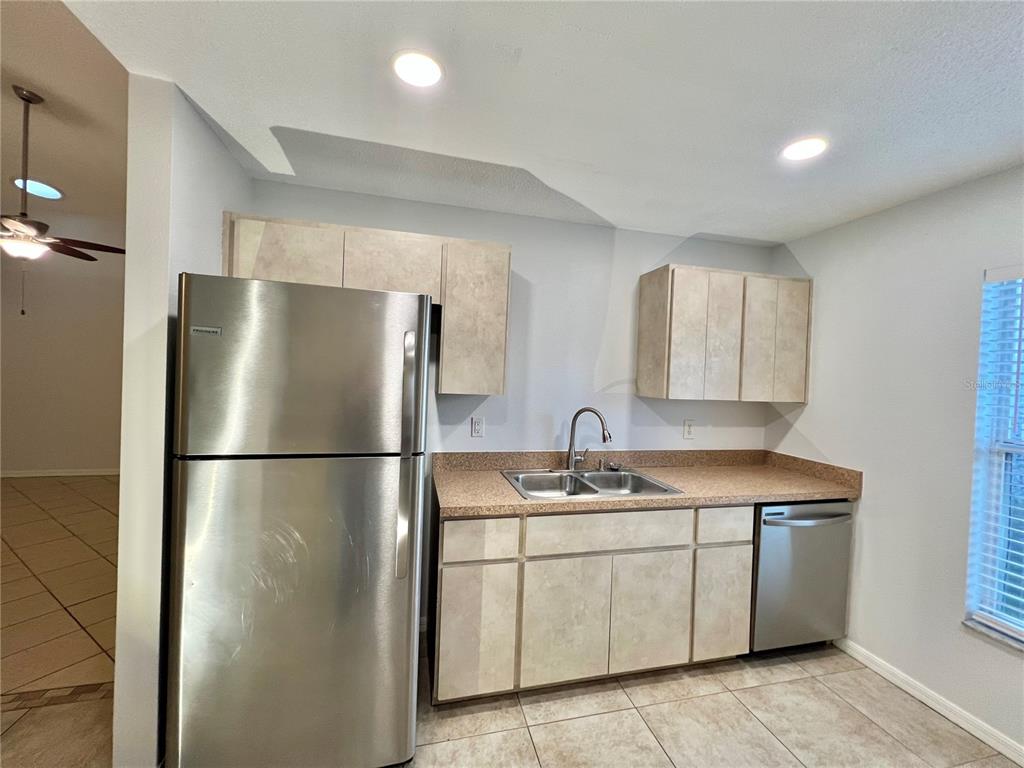7469 Pond Circle Spring Hill, FL 34606 - Photo 9 of 22 a kitchen with a sink a refrigerator and a mirror