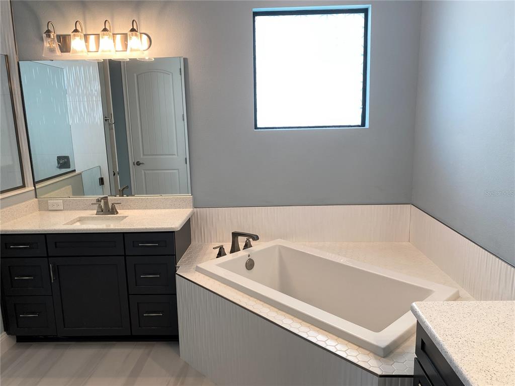 11 Rio Vista Drive Palm Coast, FL 32137 - Photo 17 of 38 a bathroom with a bathtub sink and mirror