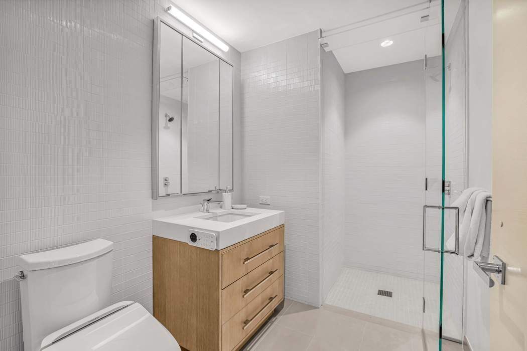 212 West 95th Street, Unit 17B Manhattan, NY 10025 - Photo 11 of 24 a bathroom with a sink a toilet and shower