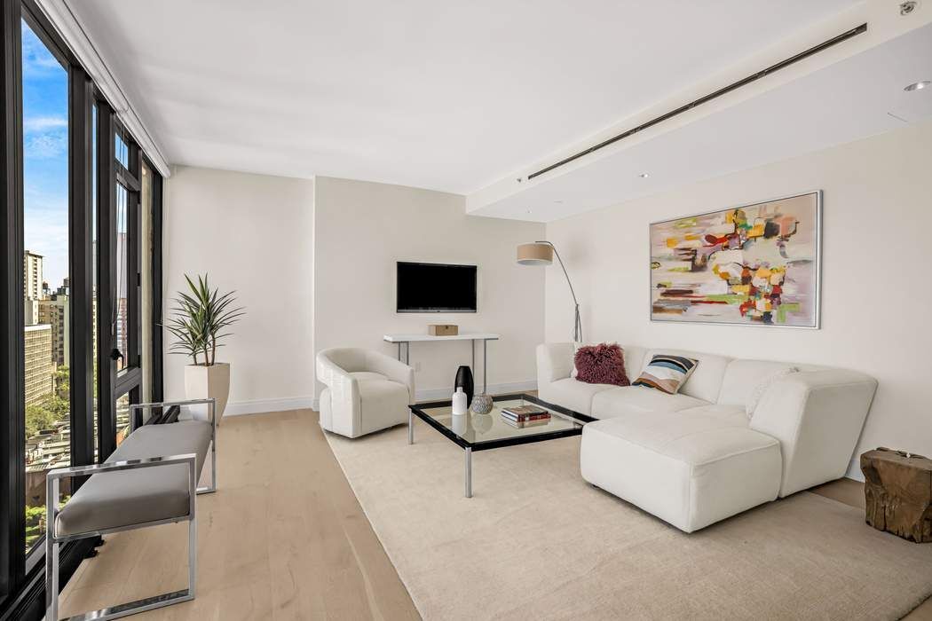 212 West 95th Street, Unit 17B Manhattan, NY 10025 - Photo 2 of 24 a living room with furniture and a flat screen tv