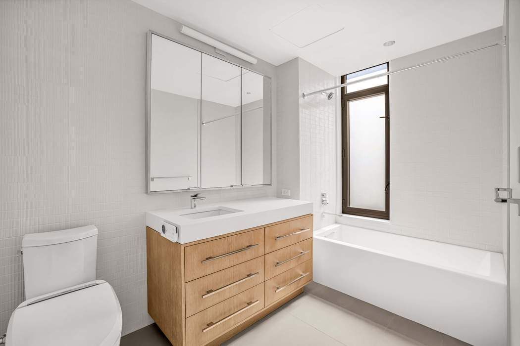 212 West 95th Street, Unit 17B Manhattan, NY 10025 - Photo 9 of 24 a bathroom with a granite countertop sink a toilet and bathtub