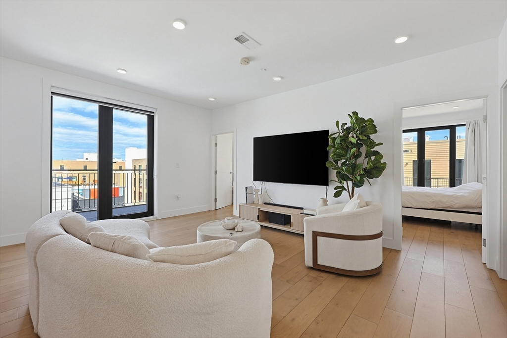 30 Penniman Road, Unit 605 Boston, MA 02134 - Photo 2 of 19 a living room with furniture and a flat screen tv