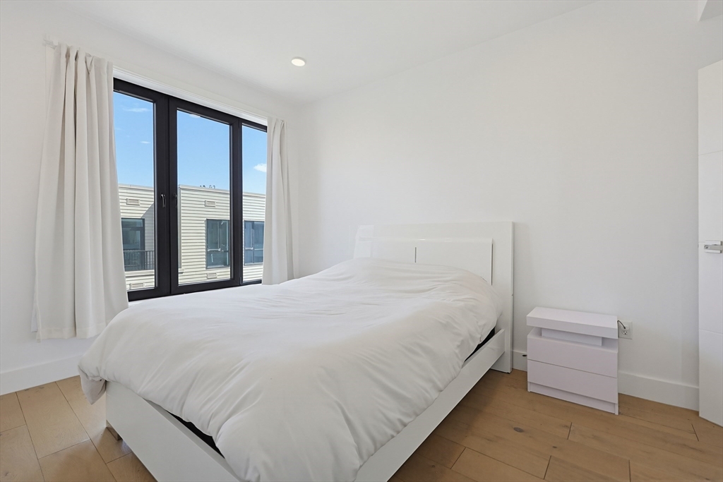 30 Penniman Road, Unit 605 Boston, MA 02134 - Photo 6 of 19 a large bed sitting in a bedroom next to a window