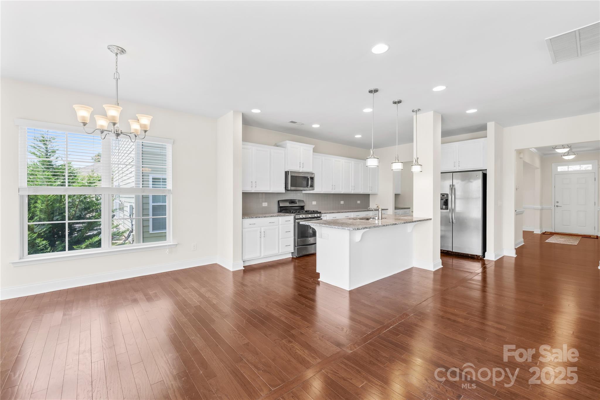 586 Brookhaven Drive Fort Mill, SC 29708 - Photo 23 of 47 a view of kitchen with granite countertop kitchen island wooden floors stainless steel appliances and white cabinets