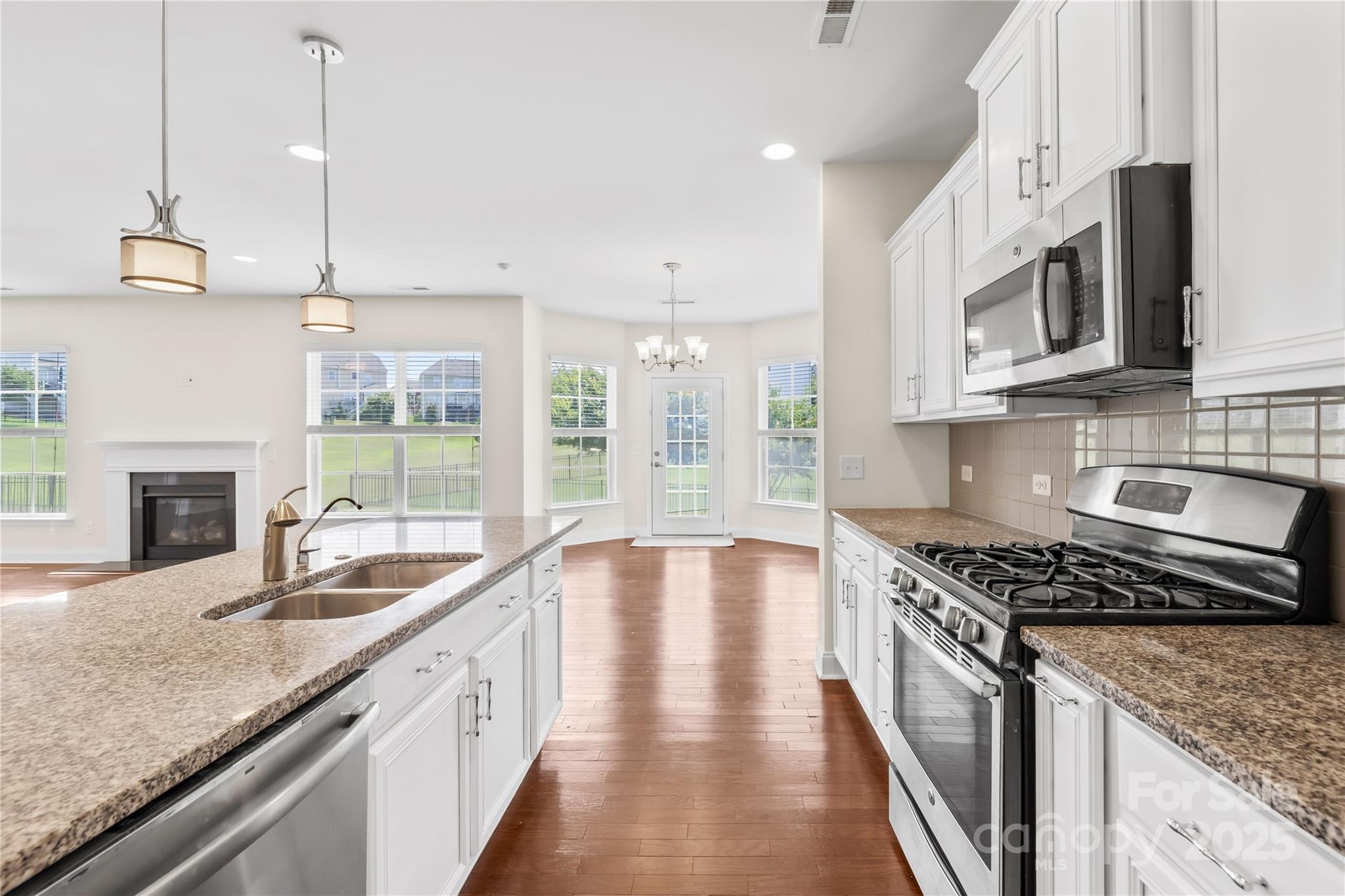 586 Brookhaven Drive Fort Mill, SC 29708 - Photo 25 of 47 a kitchen with stainless steel appliances granite countertop a sink a stove and a granite counter tops with wooden floors