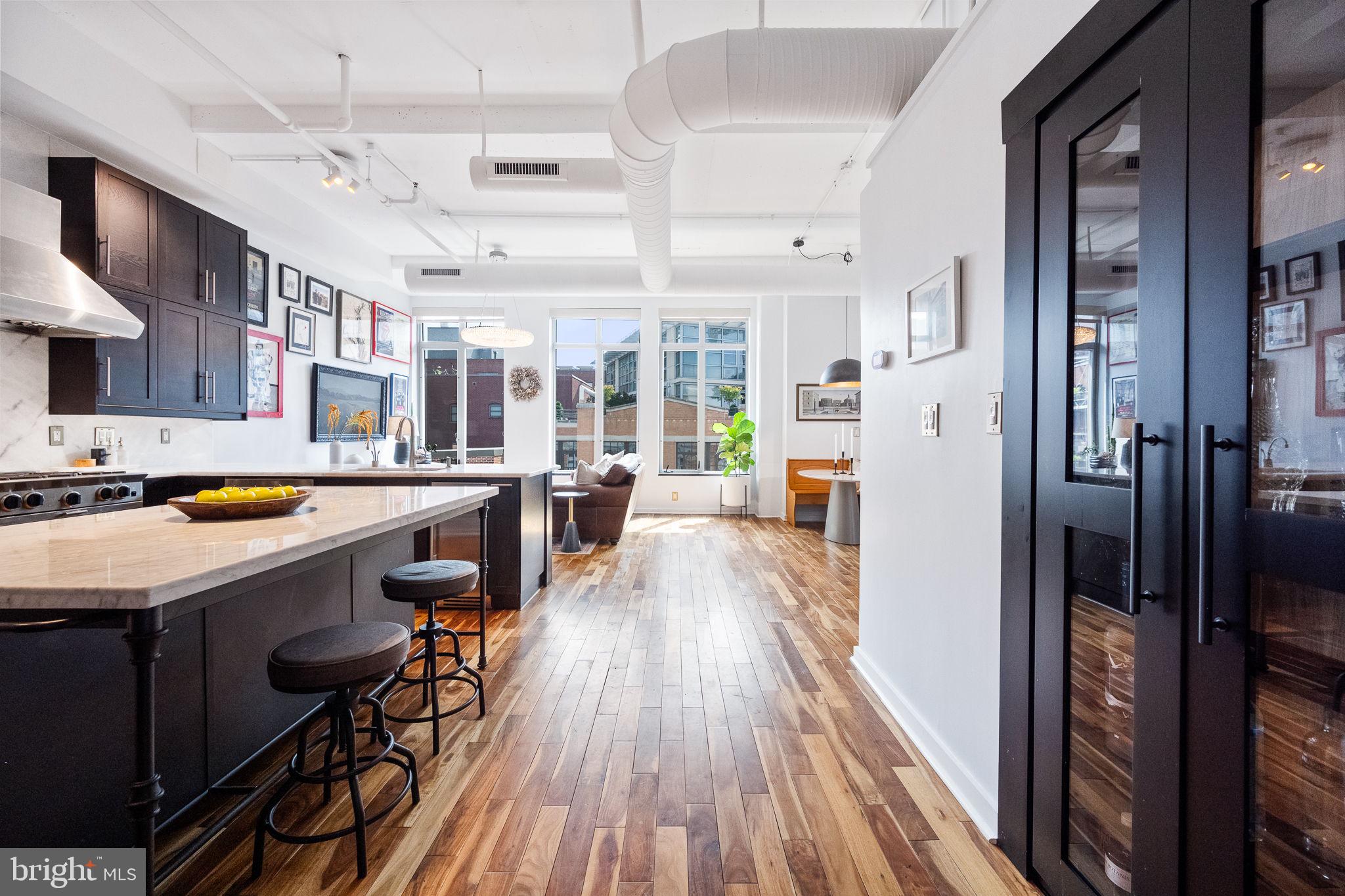a kitchen with stainless steel appliances a lot of counter space and wooden floors