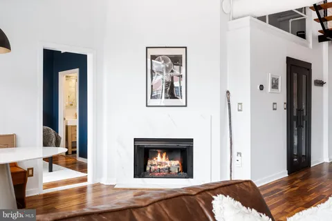 a bedroom with a bed and a fireplace with wooden floor