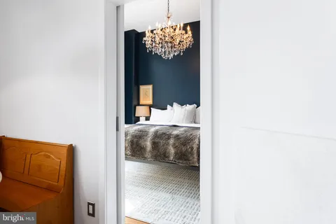 a bedroom with a bed and a chandelier