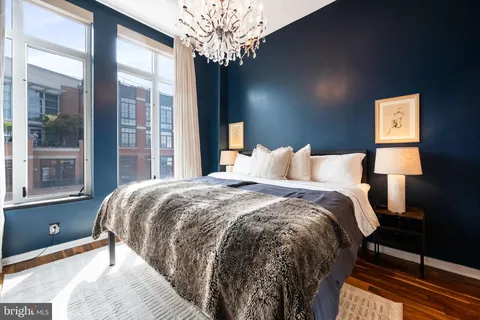 a bedroom with a bed and a large window