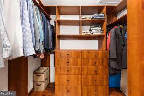 a view of walk in closet with clothes and shoes