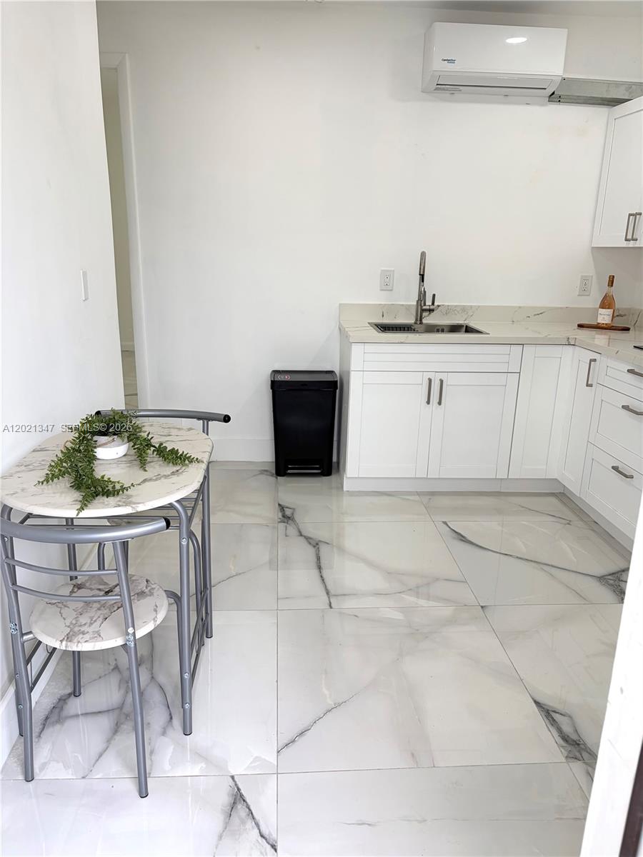 13065 Southwest 263rd Terrace, Unit 2 Homestead, FL 33032 - Photo 3 of 15 a kitchen with a sink a table and chairs